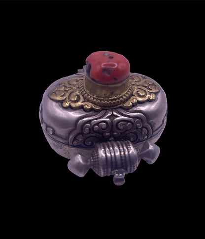 An antique silver and coral ghau amulet