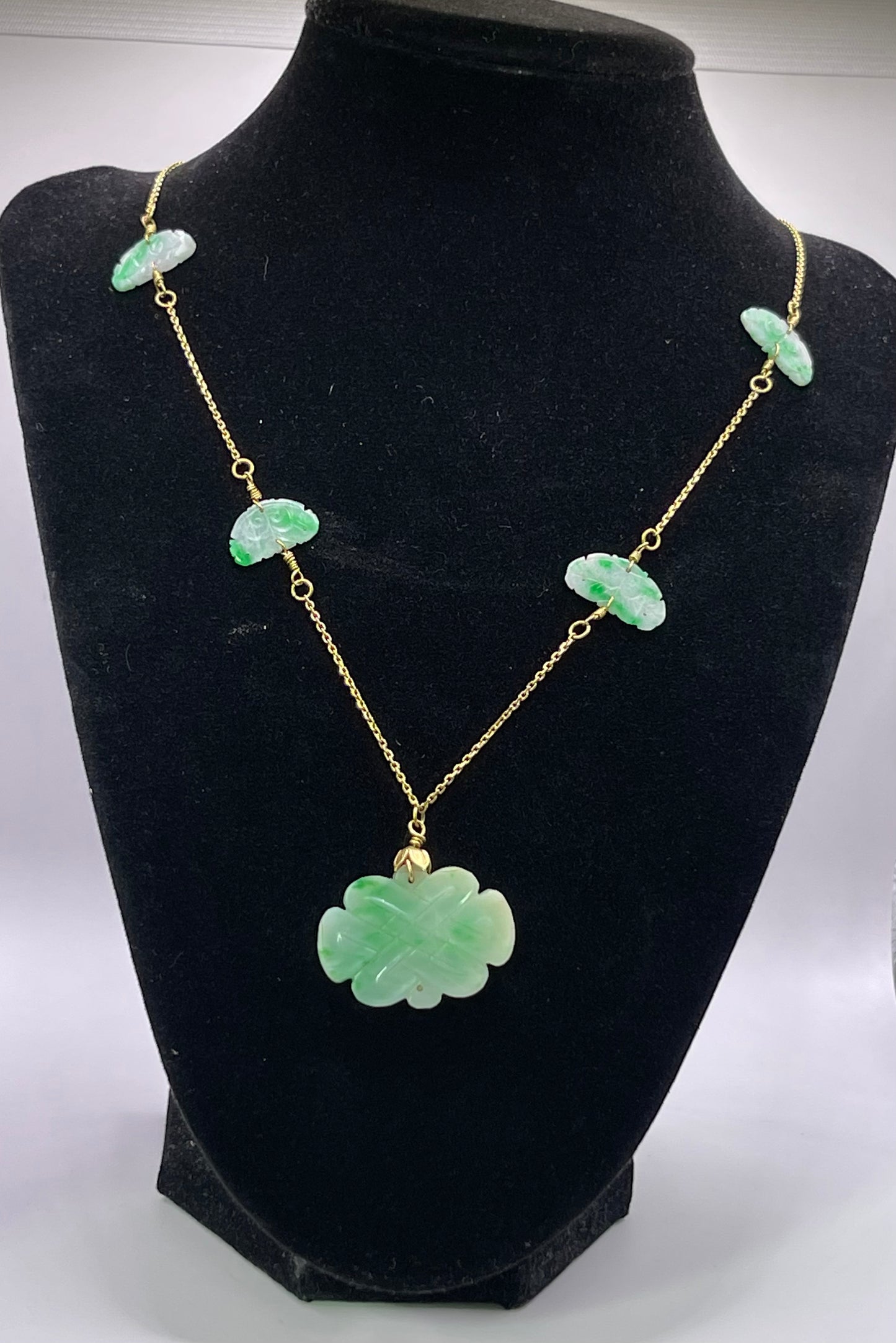 A vintage Art Deco style necklace with an antique apple green jade carved plaque and smaller plaques on 14kt chain