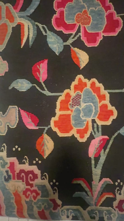 An early 20th C., antique black Tibetan with floral motif rug