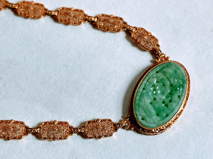 A vintage Art Deco style necklace with a antique apple green jade carved plaque in a 14kt filigree setting