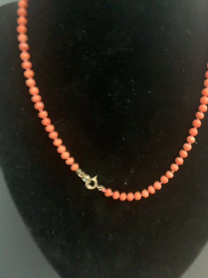 A coral necklace with a carved coral pendant