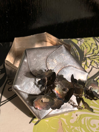 A hexagonal silver box with lid
