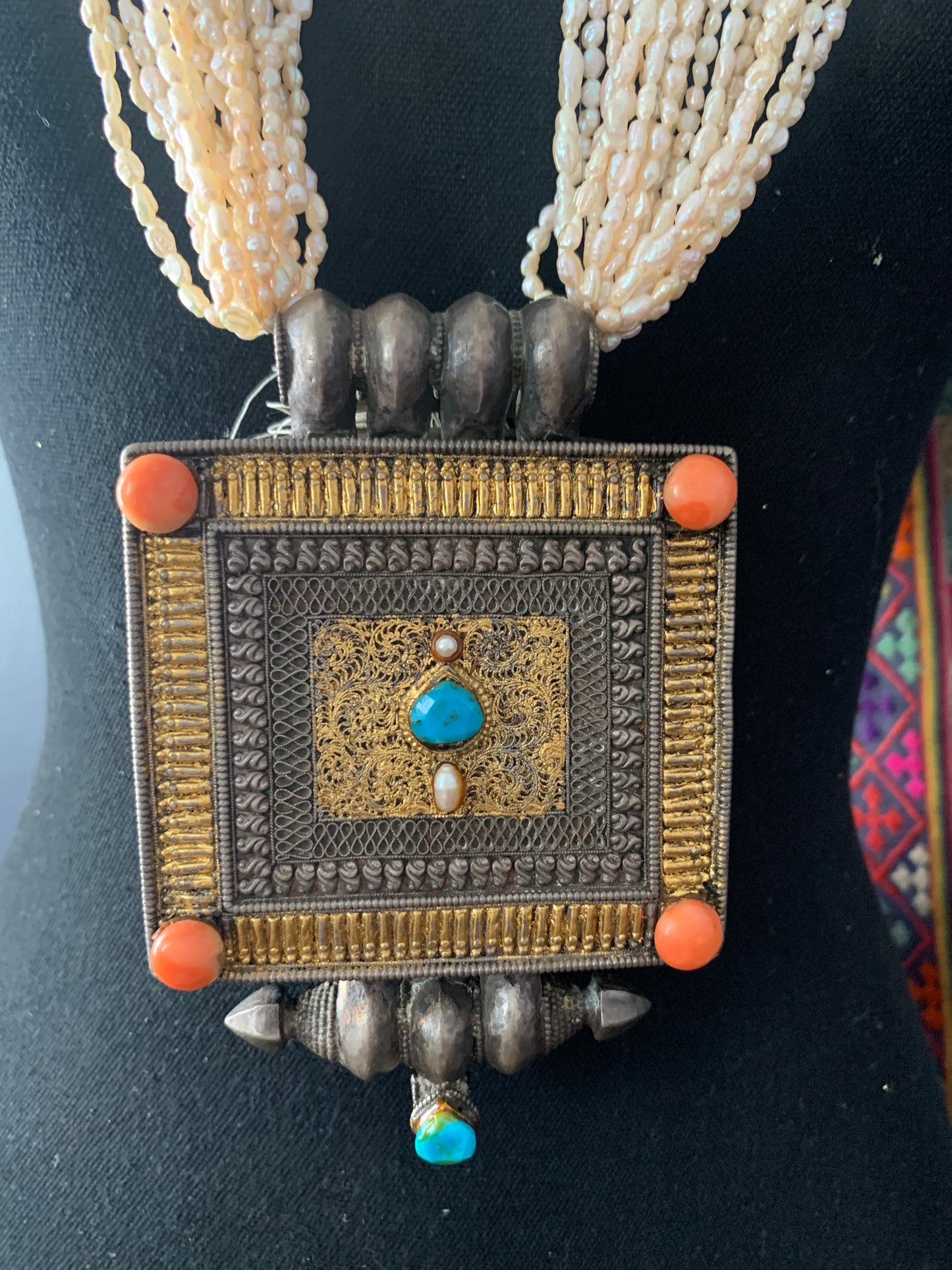 A Tibetan silver ghau with pearls and turquoise.