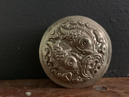 A cylindrical silver box