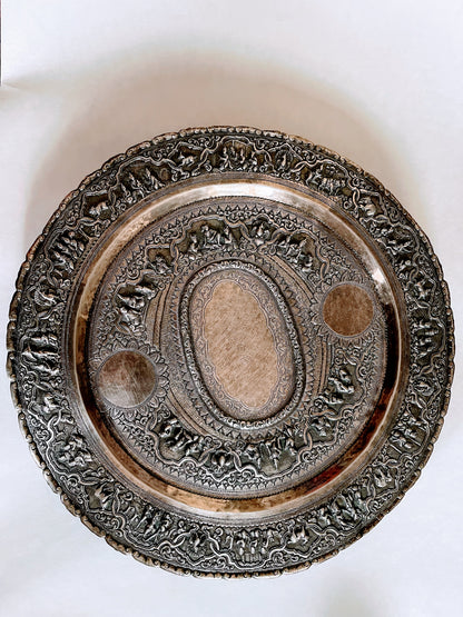 A Burmese antique elaborately carved circular tray and oval shaped jug with a pointed mug.