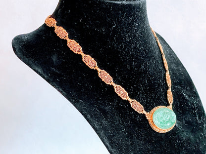 A vintage Art Deco style necklace with a antique apple green jade carved plaque in a 14kt filigree setting