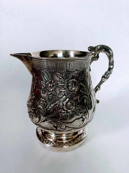 A silver creamer (roses)