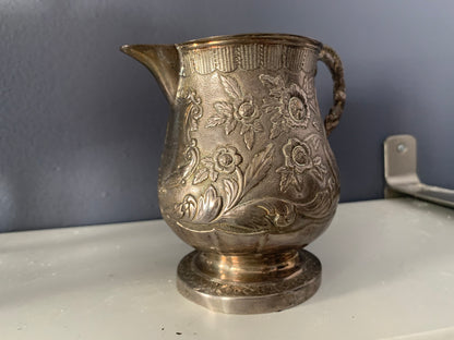 A silver creamer (roses)