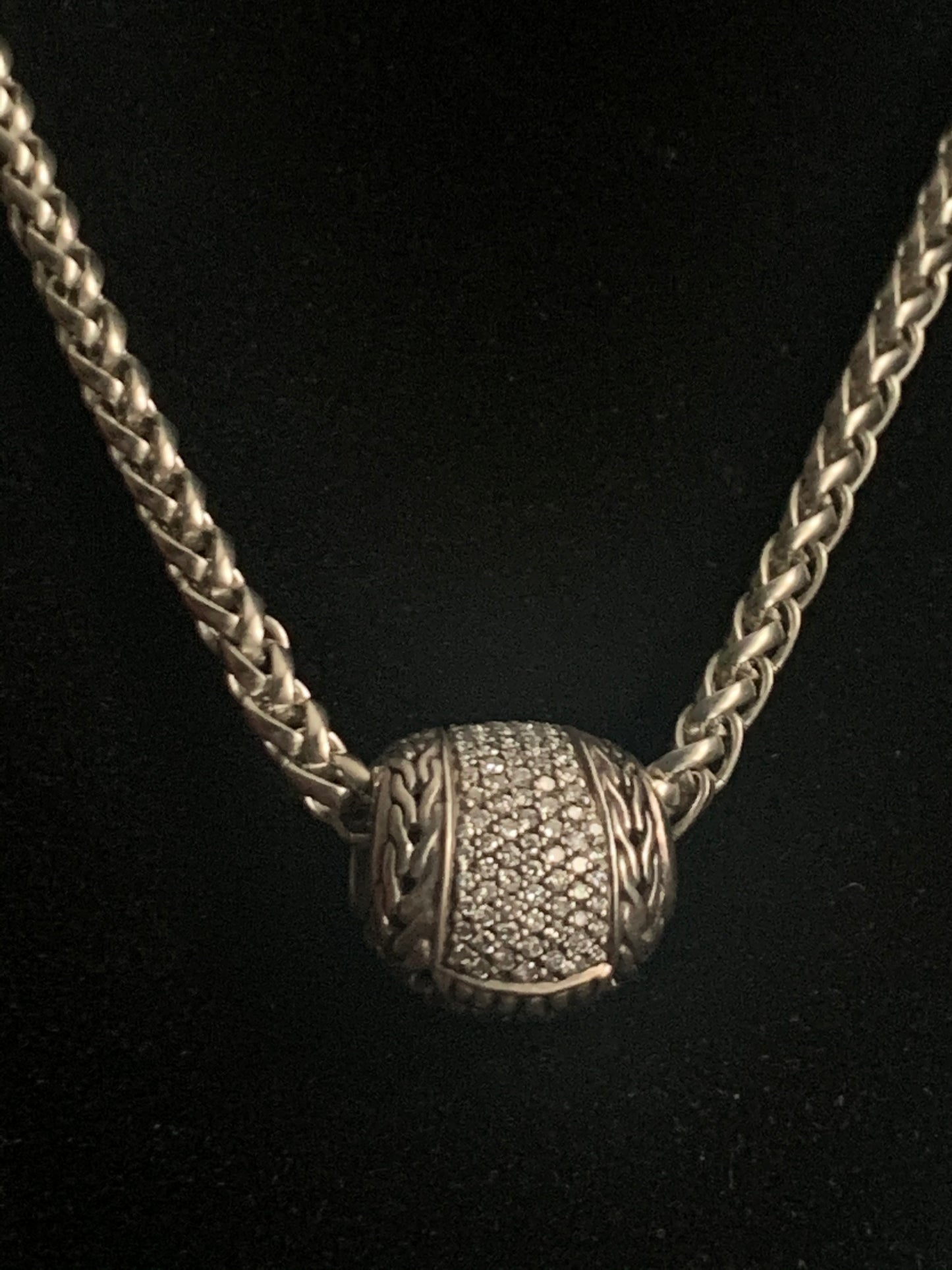 A silver chain with diamond pave pendant