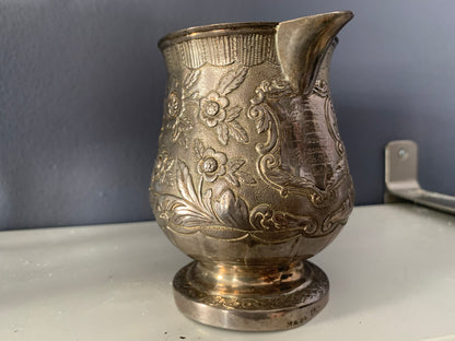 A silver creamer (roses)