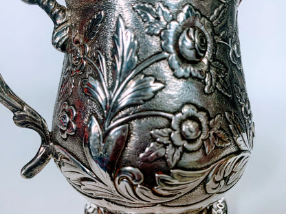A silver creamer (roses)
