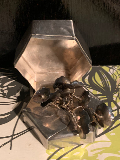 A hexagonal silver box with lid
