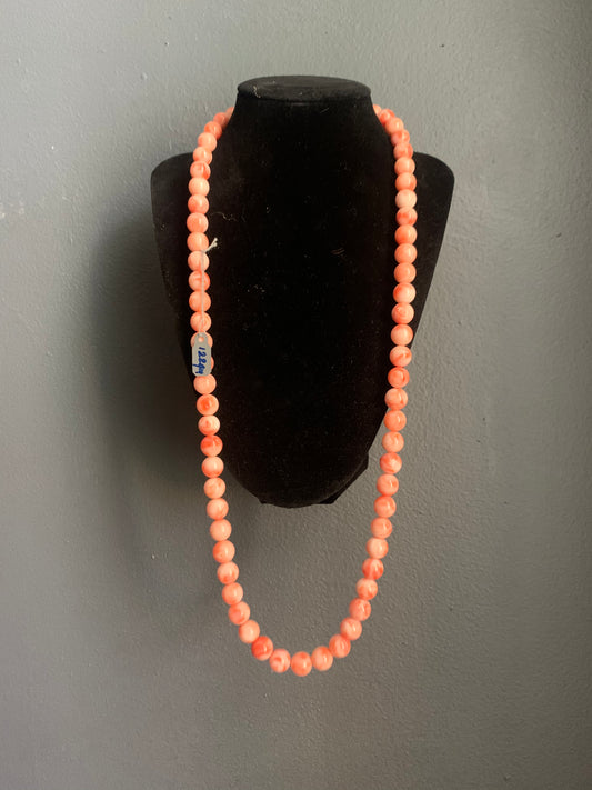 A salmon colored coral -like bead necklace