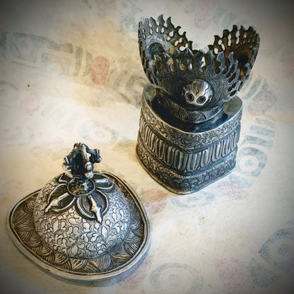 An antique silver kapala stand and cover