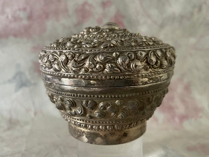An antique silver south East Asian round box with lid