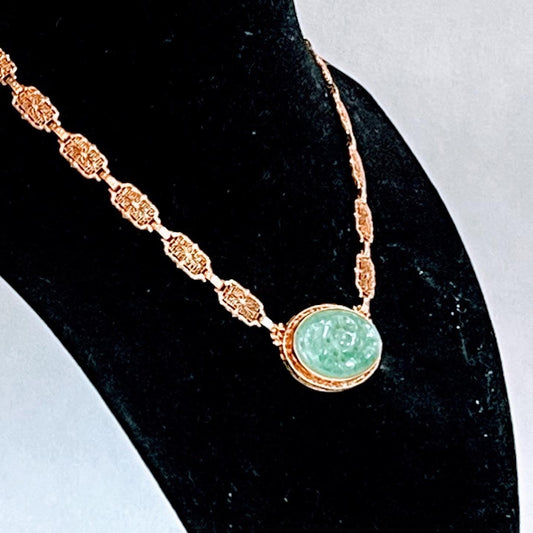 A vintage Art Deco style necklace with a antique apple green jade carved plaque in a 14kt filigree setting