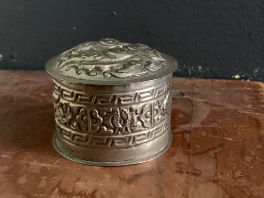 A cylindrical silver box