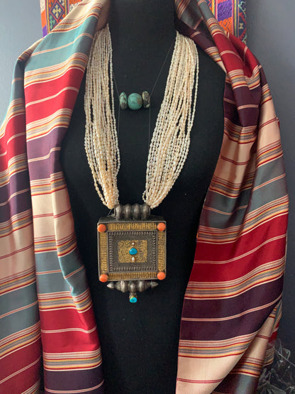 A Tibetan silver ghau with pearls and turquoise.