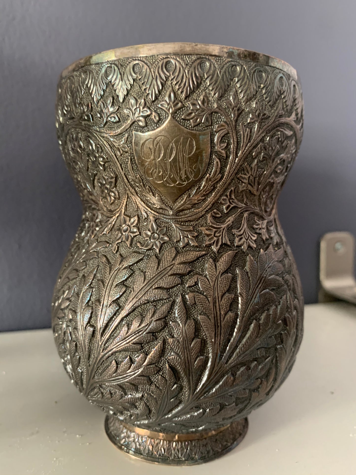 An intricately carved silver mug
