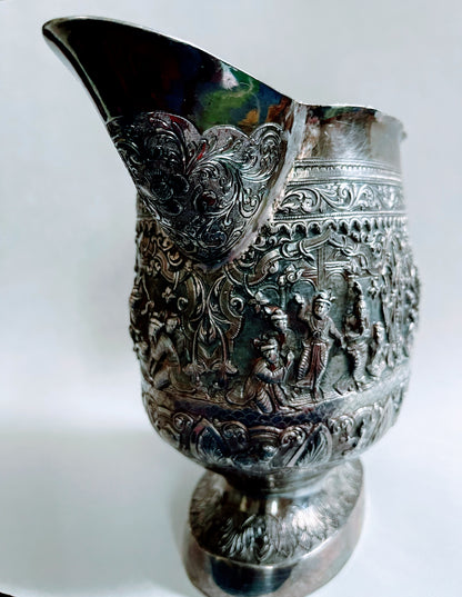 A Burmese antique elaborately carved circular tray and oval shaped jug with a pointed mug.