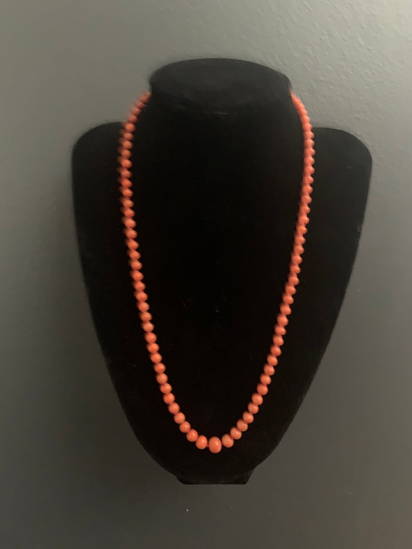 A coral necklace with a carved coral pendant