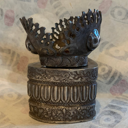 An antique silver kapala stand and cover
