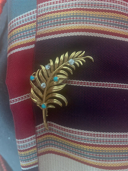 A 18kt gold brooch with turquoise and diamonds.