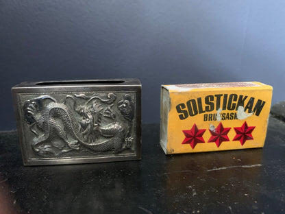A silver matchbox cover