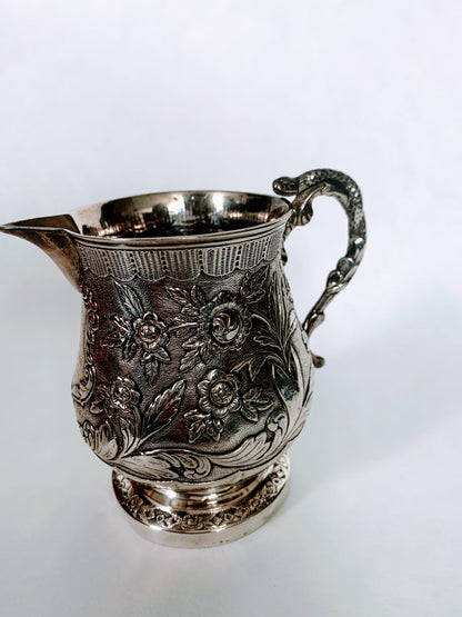 A silver creamer (roses)