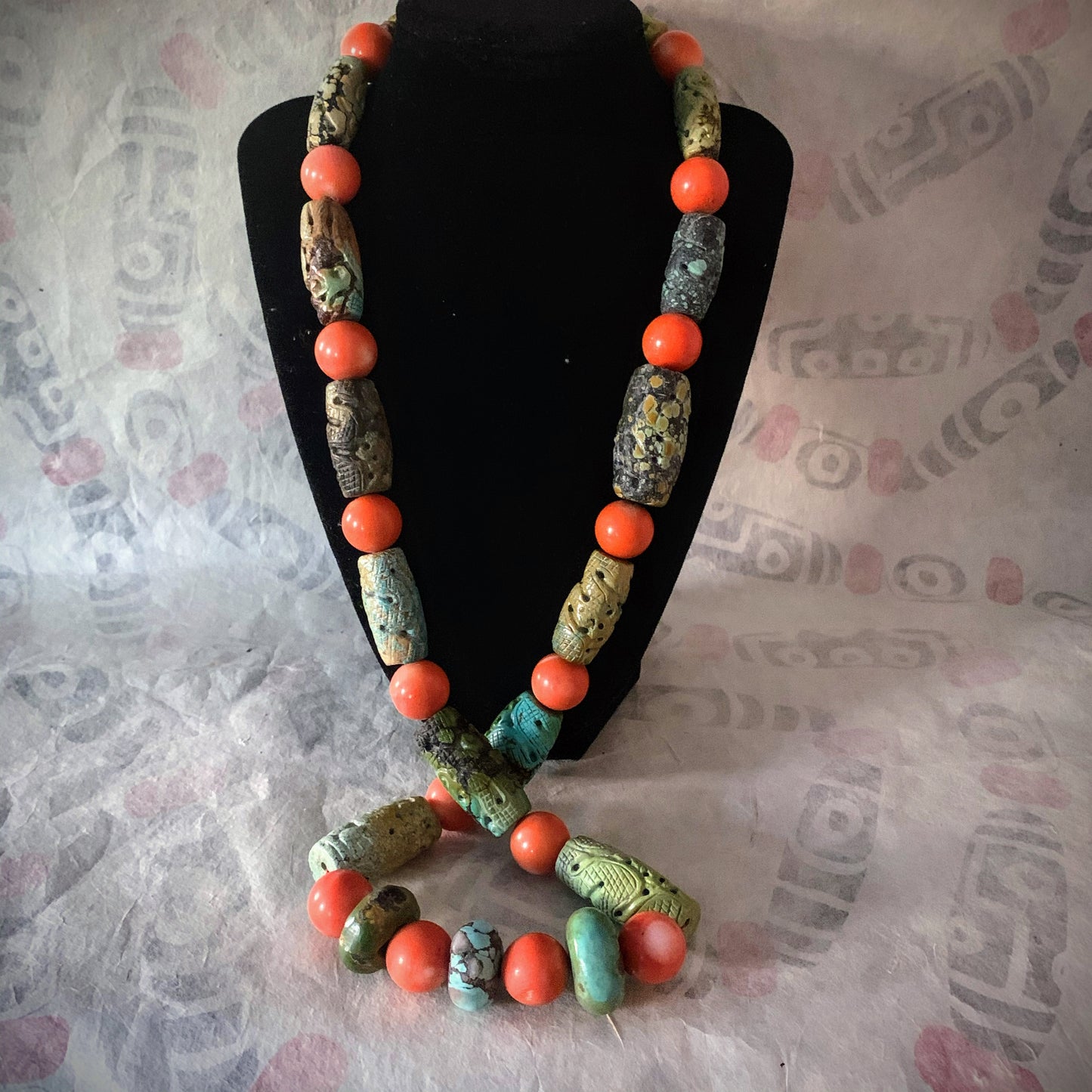 A necklace with antique carved turquoise and vintage coral beads