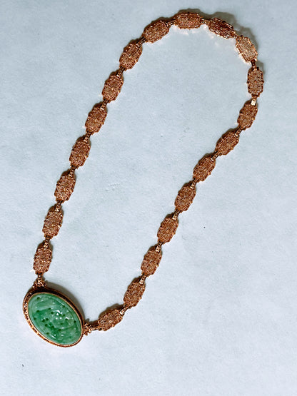 A vintage Art Deco style necklace with a antique apple green jade carved plaque in a 14kt filigree setting