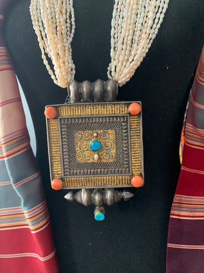 A Tibetan silver ghau with pearls and turquoise.