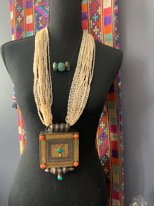 A Tibetan silver ghau with pearls and turquoise.