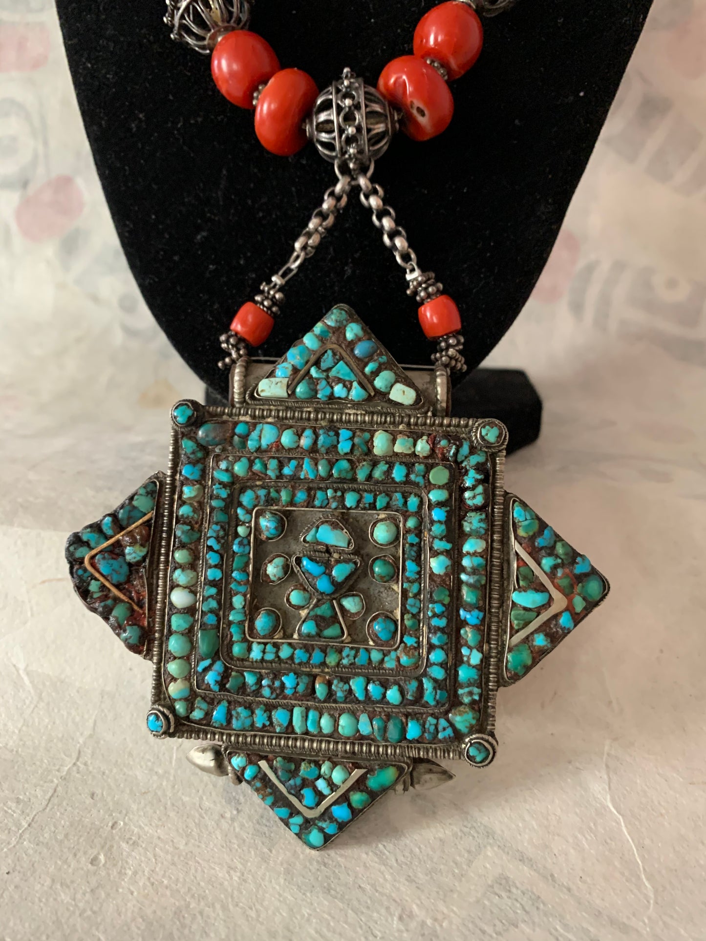 A vintage Tibetan silver and turquoise ghau pendant with an antique red coral bead and silver bead necklace