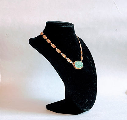A vintage Art Deco style necklace with a antique apple green jade carved plaque in a 14kt filigree setting