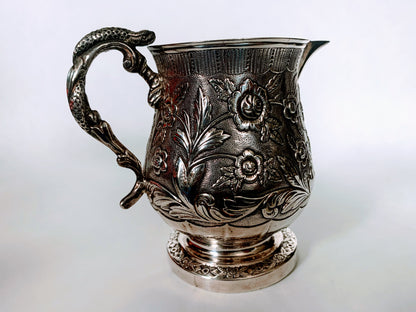A silver creamer (roses)