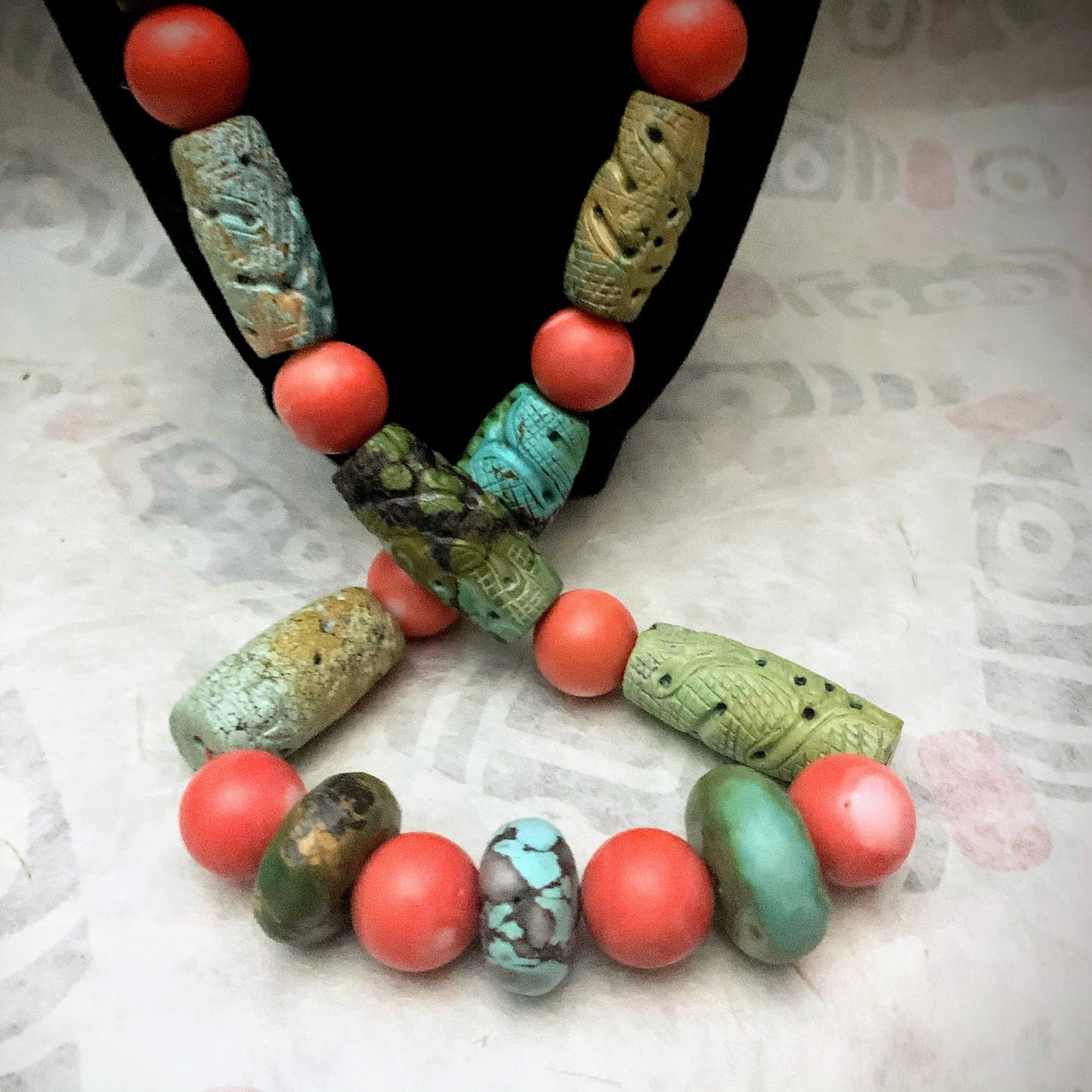A necklace with antique carved turquoise and vintage coral beads