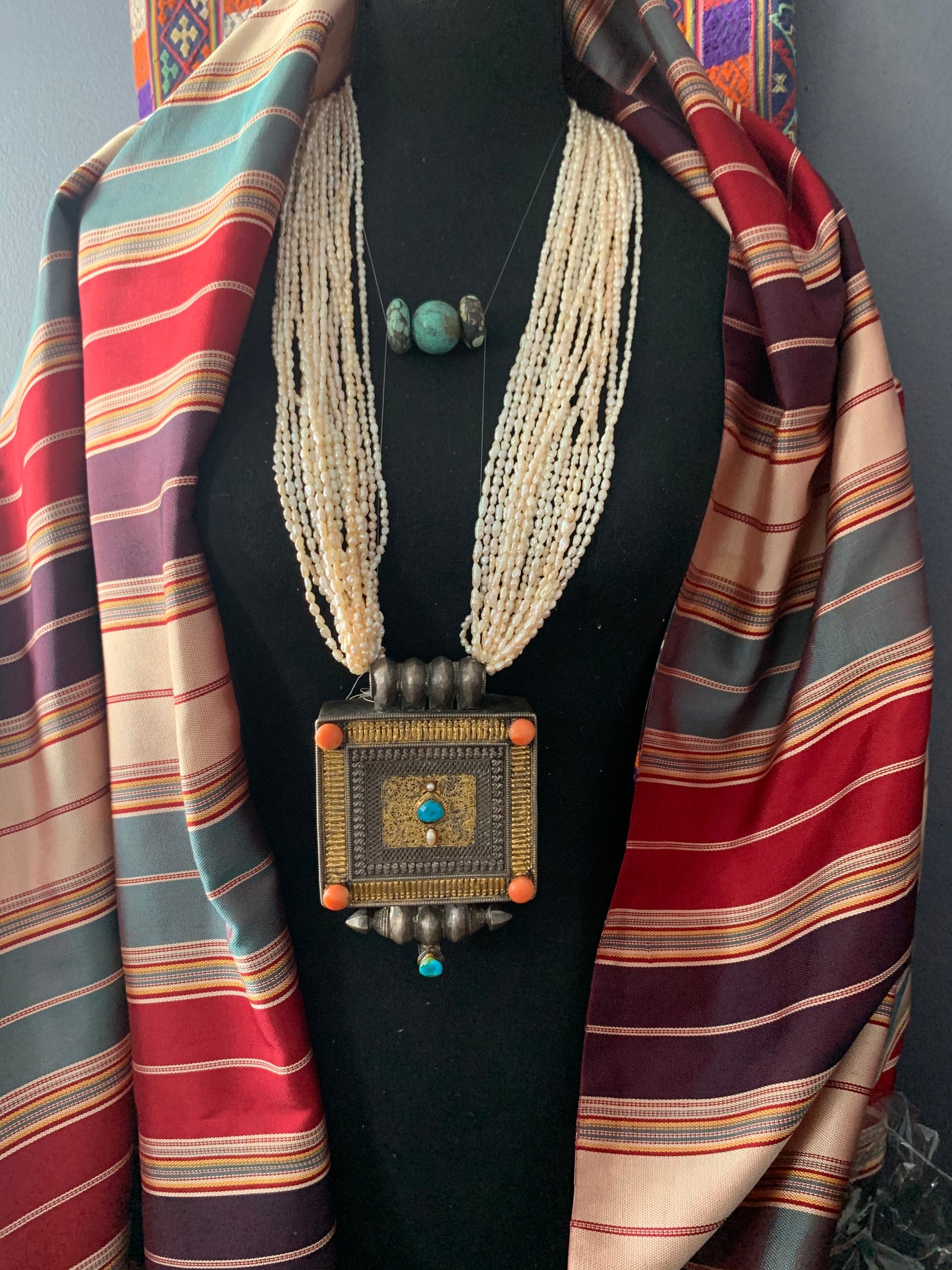 A Tibetan silver ghau with pearls and turquoise.