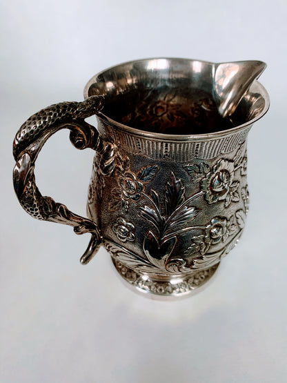 A silver creamer (roses)