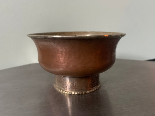 A copper bowl With silver details