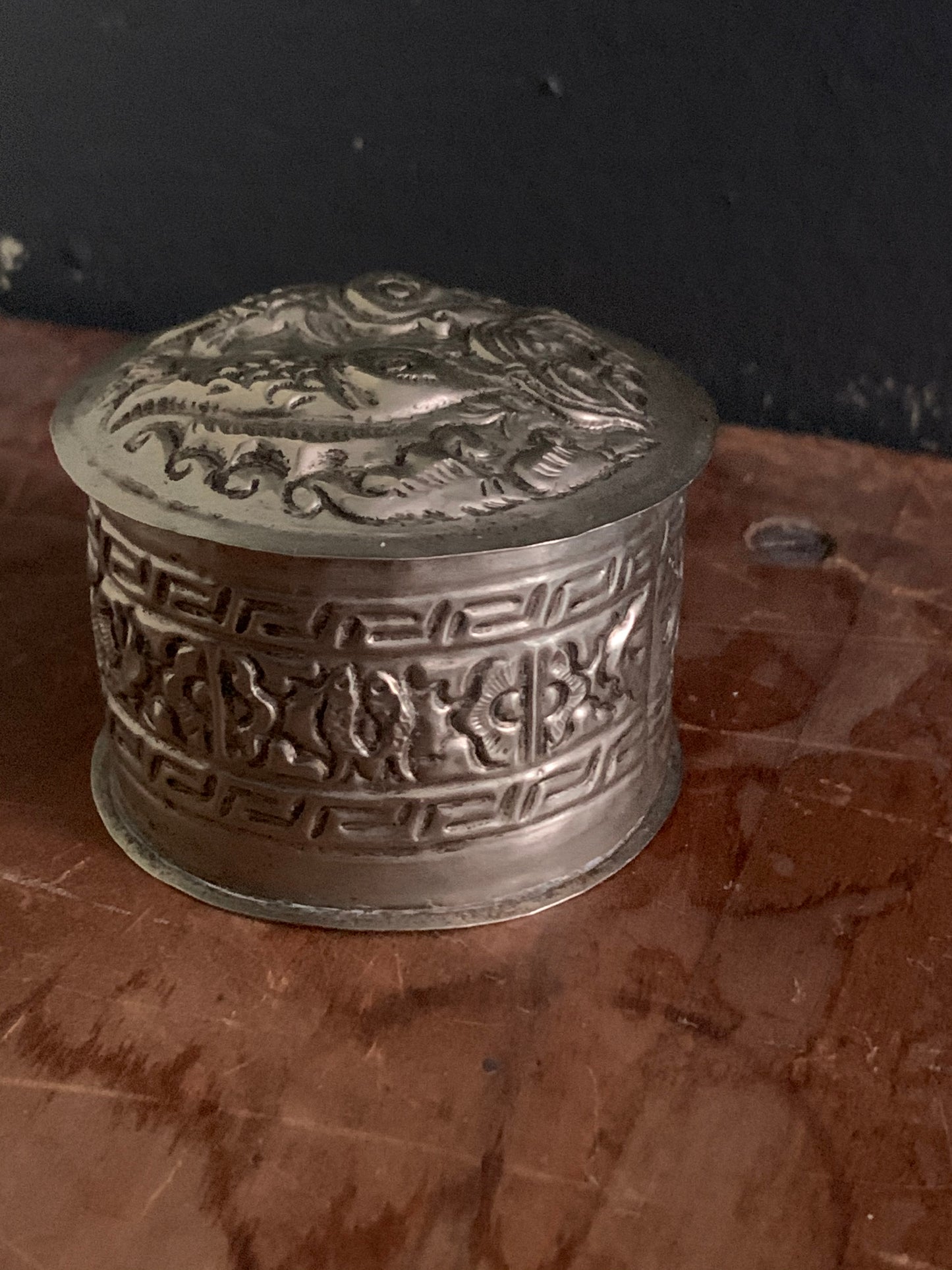 A cylindrical silver box