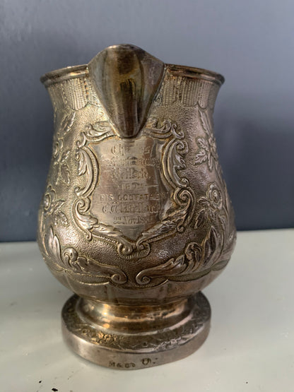 A silver creamer (roses)