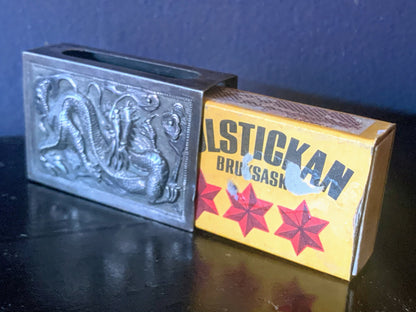 A silver matchbox cover