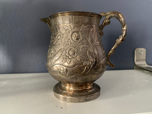 A silver creamer (roses)