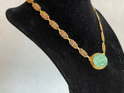 A vintage Art Deco style necklace with a antique apple green jade carved plaque in a 14kt filigree setting