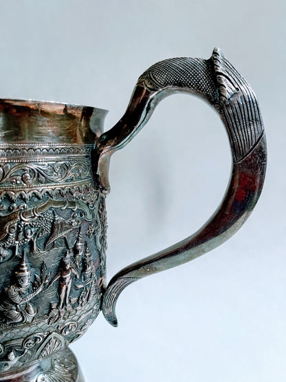A Burmese antique elaborately carved circular tray and oval shaped jug with a pointed mug.
