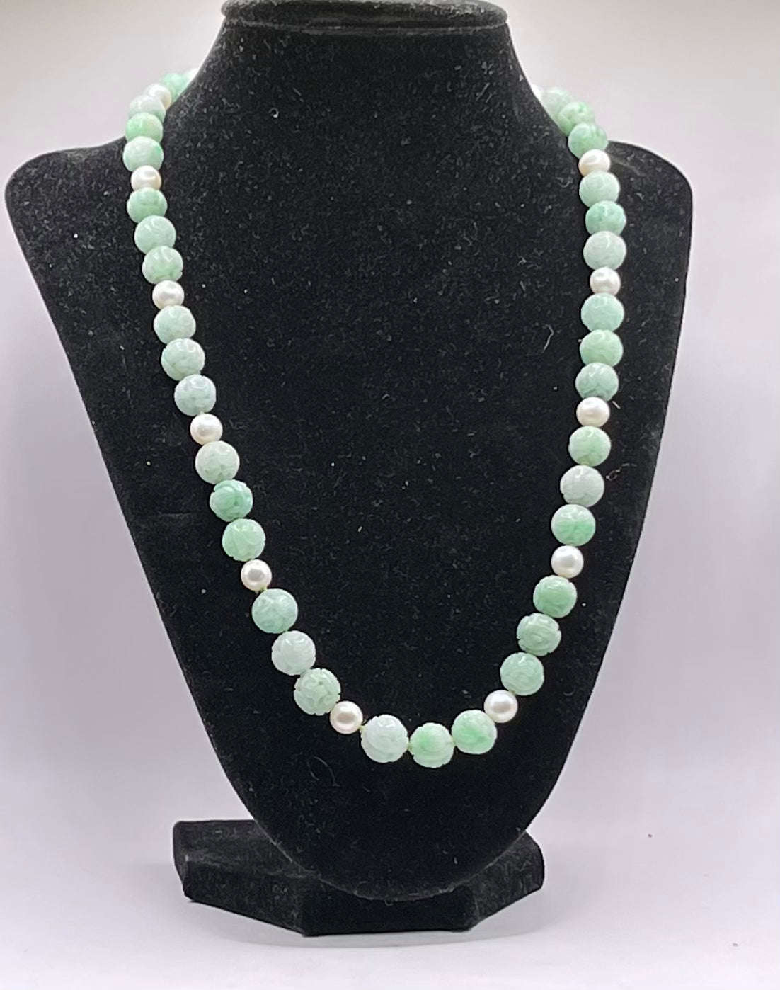 A necklace with vintage carved jade shou beads and pearls