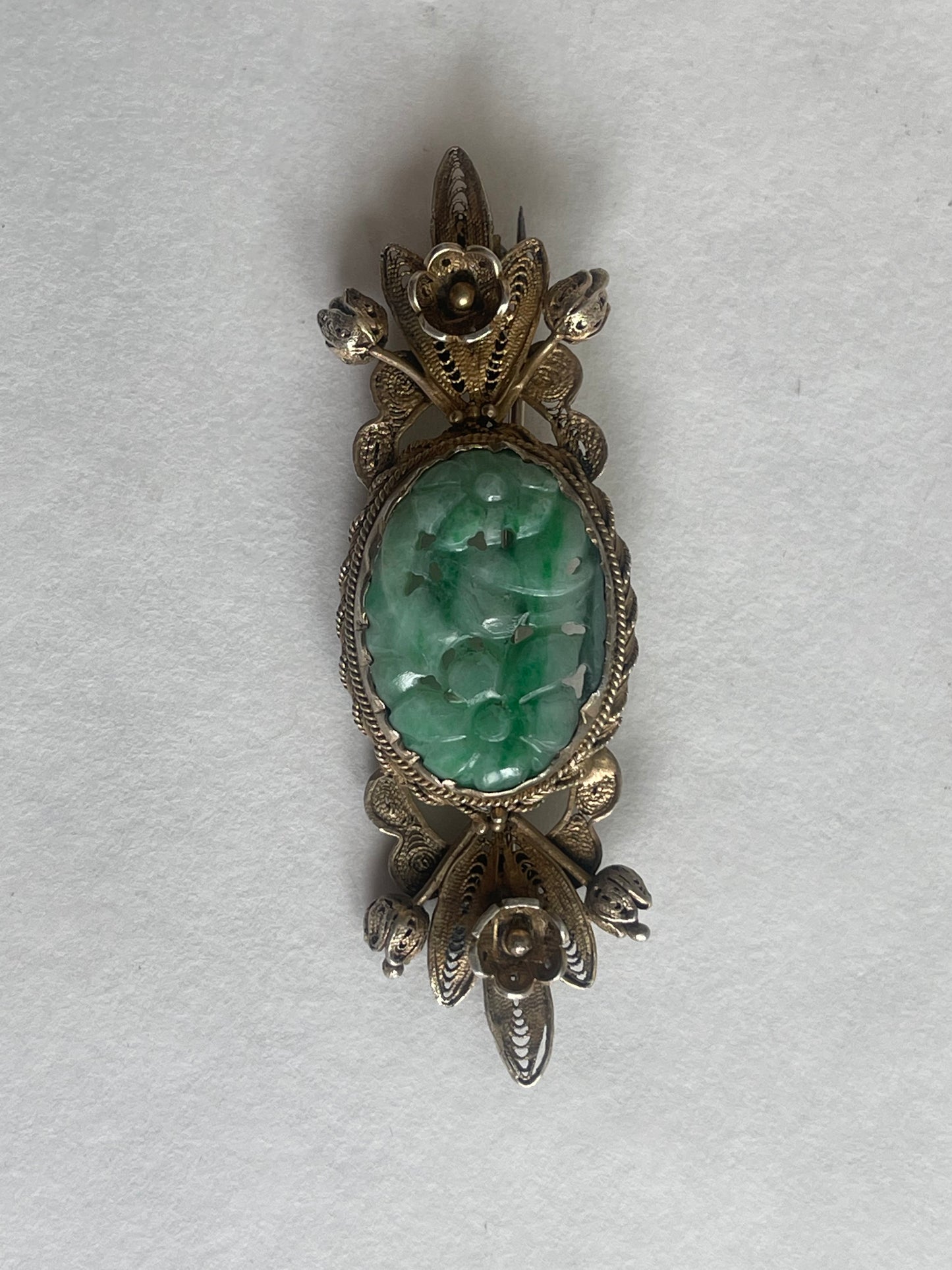 A vintage jade brooch In a gilded silver setting