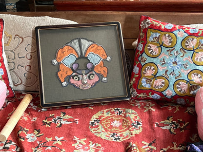 An antique childrens collar with an animal design in a box frame
