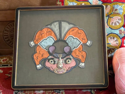 An antique childrens collar with an animal design in a box frame